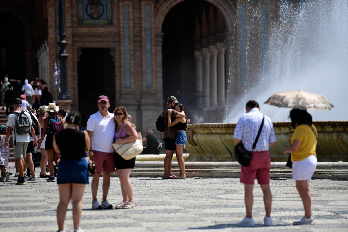 Turistas se refrescam na fonte da Plaza de España durante a onda de calor extremo em Sevilha/CRISTINA QUICLER / AFP