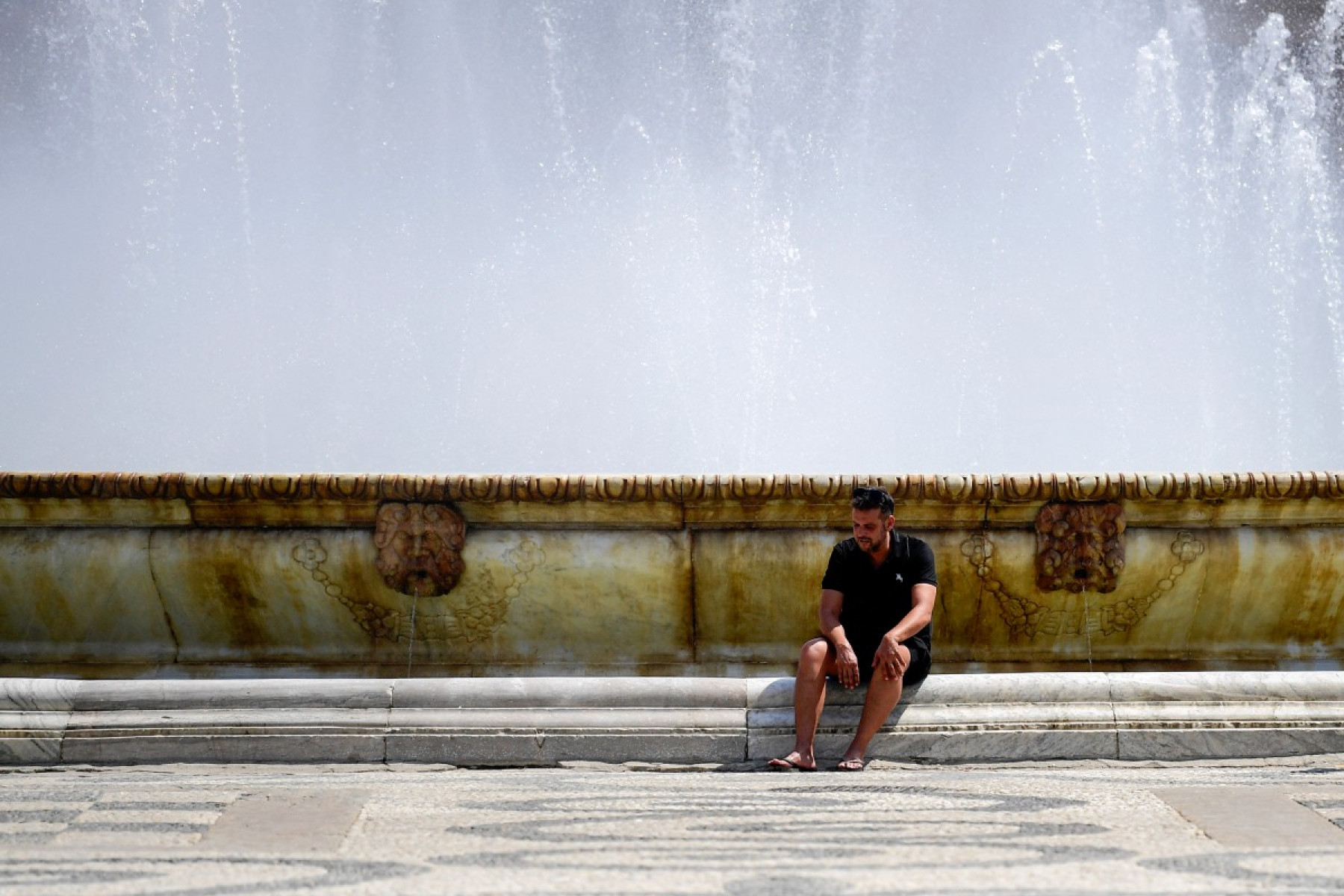 Turistas se refrescam na fonte da Plaza de España durante a onda de calor extremo em Sevilha