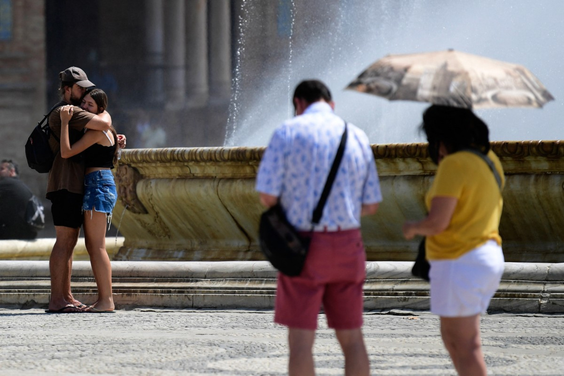 Turistas se refrescam na fonte da Plaza de España durante a onda de calor extremo em Sevilha