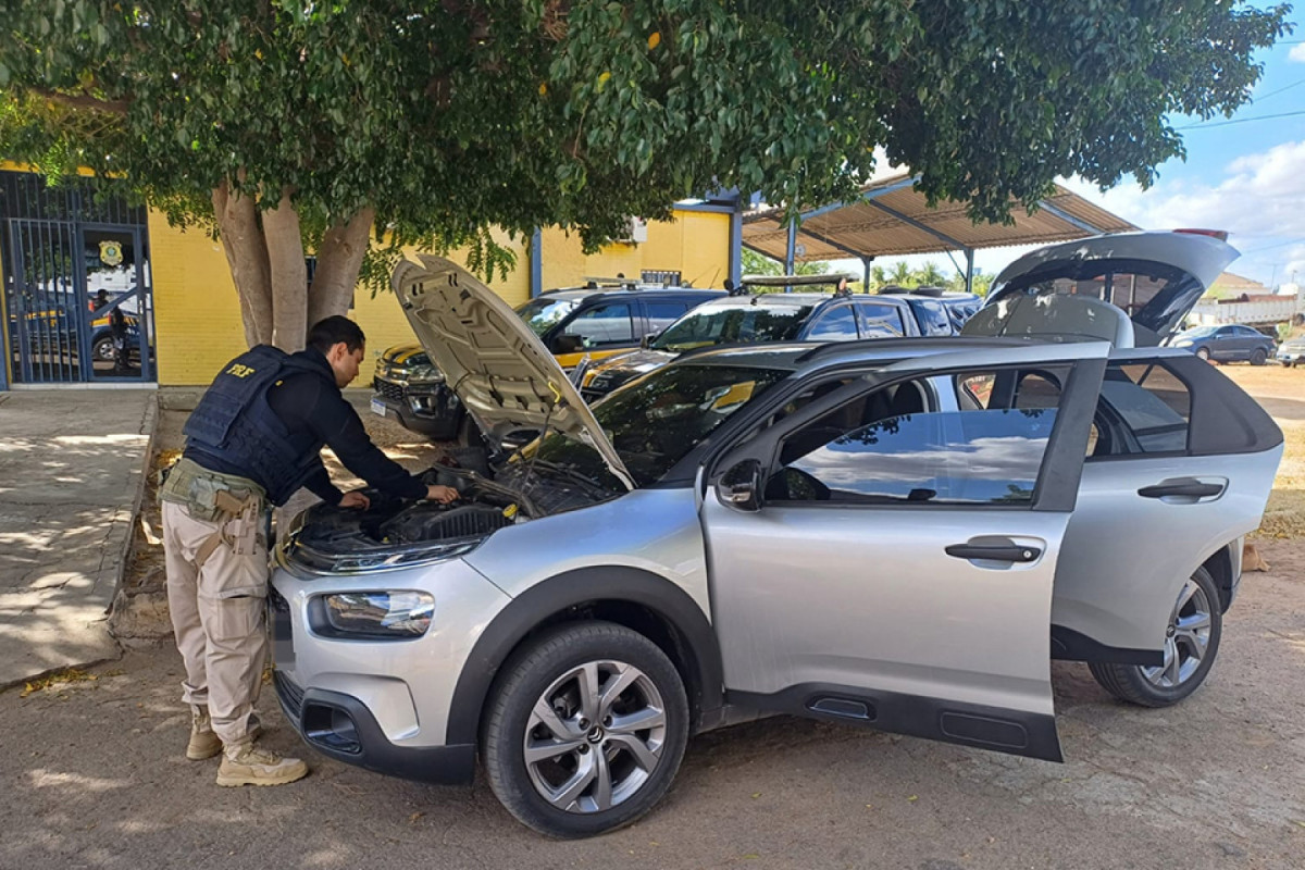 Agente da PRF faz vistoria no carro após a tentativa de fuga/DIVULGAÇÃO/PRF