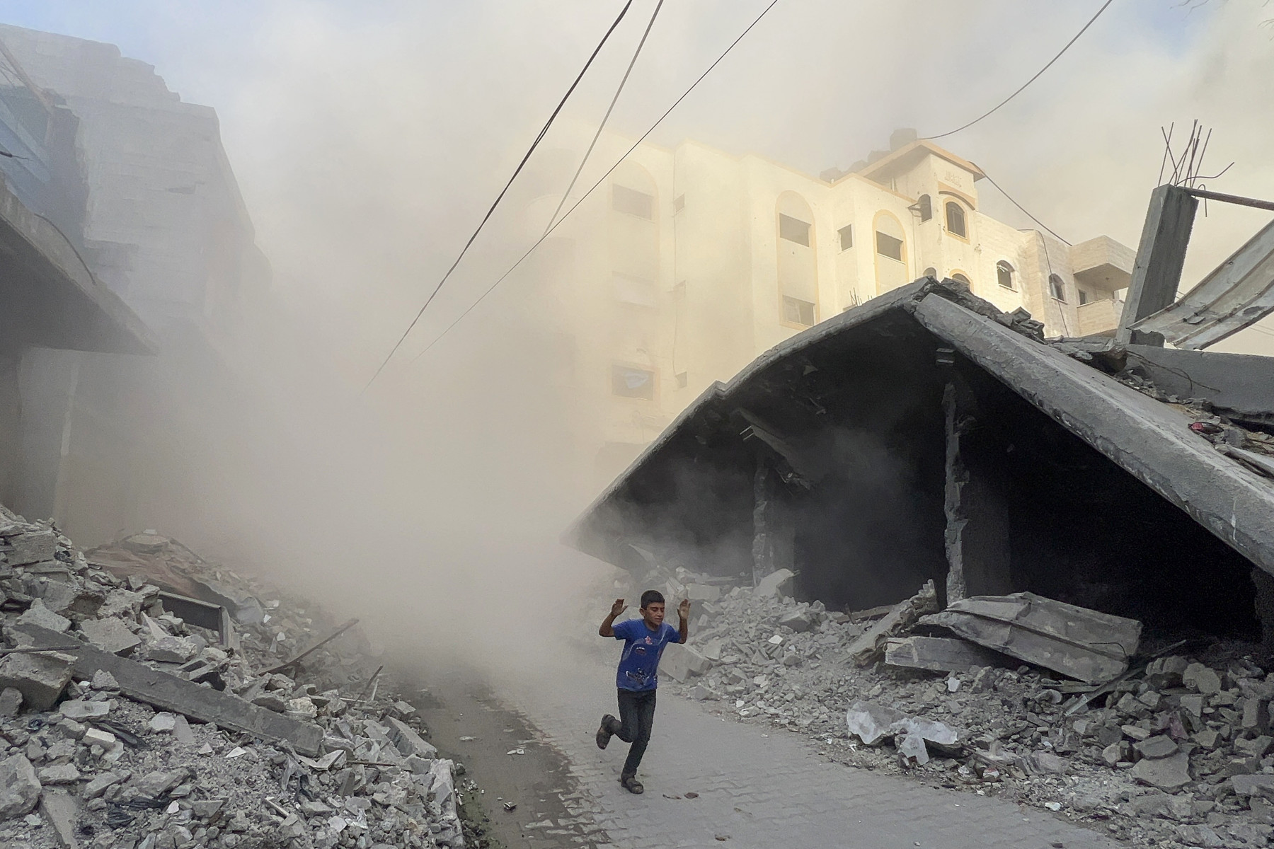 
 Um menino palestino foge do local dos ataques aéreos israelenses contra um prédio de seis andares no bairro de Saftawi, a oeste de Jabalia, no norte da Faixa de Gaza, em 19 de agosto de 2025.