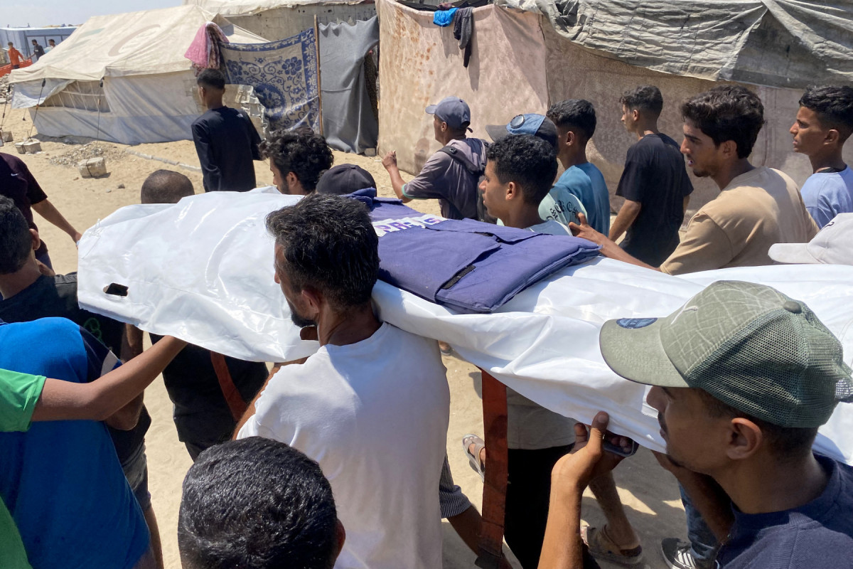 Enlutados carregam o corpo de um dos cinco jornalistas mortos em um ataque israelense ao hospital Nasser em Khan Yunis, no sul da Faixa de Gaza