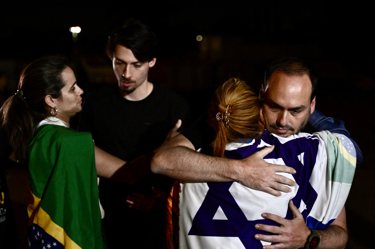 Carlos Bolsonaro (D) e Jair Renan Bolsonaro, filhos do ex-presidente brasileiro Jair Bolsonaro, cumprimentam apoiadores do pai durante uma vigília perto da casa do ex-presidente em Brasília, em 1º de setembro de 2025. O ex-capitão do Exército é acusado de conspirar para permanecer no poder após sua derrota eleitoral para o presidente de esquerda Luiz Inácio Lula da Silva em 2022. Uma condenação judicial — com veredito previsto para qualquer momento a partir de 2 de setembro — pode levar o homem de 70 anos à prisão, talvez pelo resto da vida. (Foto de Evaristo Sá / AFP) ( AFP) Carlos Bolsonaro (D) e Jair Renan Bolsonaro, filhos do ex-presidente brasileiro Jair Bolsonaro, cumprimentam apoiadores do pai durante uma vigília perto da casa do ex-presidente em Brasília, em 1º de setembro de 2025. O ex-capitão do Exército é acusado de conspirar para permanecer no poder após sua derrota eleitoral para o presidente de esquerda Luiz Inácio Lula da Silva em 2022. Uma condenação judicial — com veredito previsto para qualquer momento a partir de 2 de setembro — pode levar o homem de 70 anos à prisão, talvez pelo resto da vida. (Foto de Evaristo Sá / AFP)/ AFP