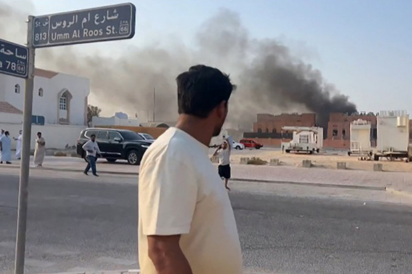 Esta captura de tela, tirada de uma filmagem da AFPTV, mostra um homem observando a fumaça subindo após as explosões na capital de Doha, Catar, em 9 de setembro de 2025. Um oficial militar israelense disse à AFP que os militares realizaram ataques aéreos em Doha em 9 de setembro, em uma operação que teve como alvo líderes seniores do grupo militante palestino Hamas. (Foto de Jacqueline PENNEY / AFPTV / AFP) ( AFP)