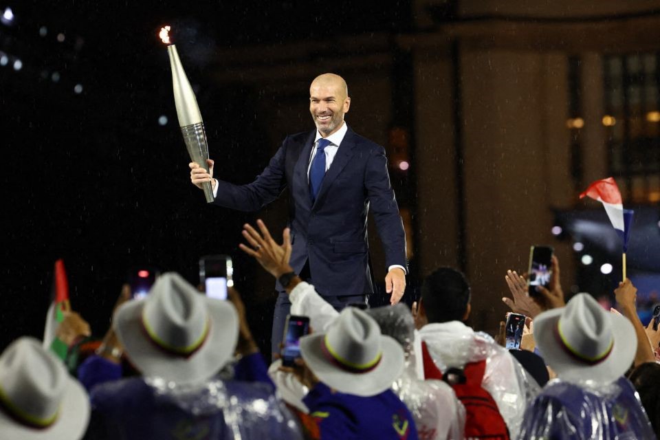 Zinedine Zidane carregando a tocha olímpica em 2024, em Paris (STEPHANIE LECOCQ / POOL / AFP) Zinedine Zidane carregando a tocha olímpica em 2024, em Paris/STEPHANIE LECOCQ / POOL / AFP