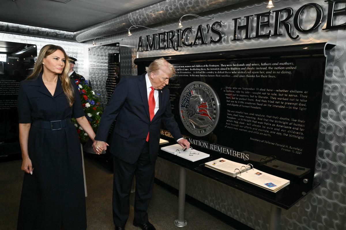 O presidente dos EUA, Donald Trump, e a primeira-dama Melania Trump autografam um livro após participarem de uma cerimônia em homenagem ao 11 de setembro no Memorial Nacional do Pentágono do 11 de setembro, em Washington (SAUL LOEB/AFP)