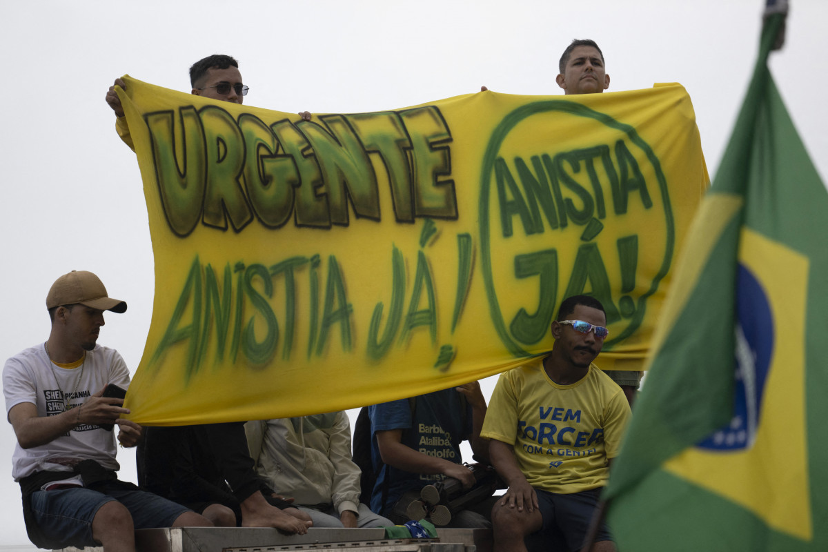  Apoiadores do ex-presidente brasileiro (2019-2022) Jair Bolsonaro, em julgamento por sua suposta participação em uma tentativa de golpe, seguram uma faixa com os dizeres "Urgente, anistia já" em uma manifestação durante o Dia da Independência, na praia de Copacabana, no Rio de Janeiro, em 7 de setembro de 2025. Bolsonaro testará sua força política com manifestações nas principais cidades do país, dias antes do veredito do Supremo Tribunal Federal (STF). O líder de extrema direita, também ex-capitão do Exército, corre o risco de até 43 anos de prisão se for condenado por tentar se agarrar ao poder após perder as eleições de 2022 para seu rival de esquerda, Luiz Inácio Lula da Silva.  (Foto: Pablo PORCIUNCULA / AFP)