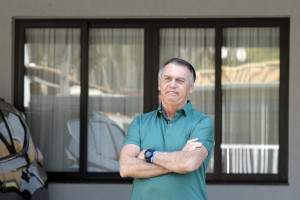 O ex-presidente brasileiro Jair Bolsonaro gesticula para a garagem de sua residência em Brasília, em 11 de setembro de 2025. (Foto de Sergio Lima / AFP)