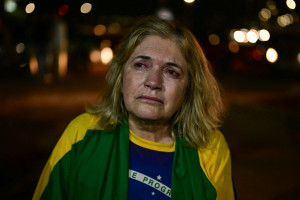 Um apoiador do ex-presidente Jair Bolsonaro chora com uma bandeira brasileira perto de sua casa em Bras&iacute;lia, em 11 de setembro de 2025. O Supremo Tribunal Federal condenou o ex-presidente Jair Bolsonaro a 27 anos de pris&atilde;o por conspira&ccedil;&atilde;o golpista, ao final de um julgamento hist&oacute;rico que dividiu o pa&iacute;s e provocou a f&uacute;ria dos EUA.