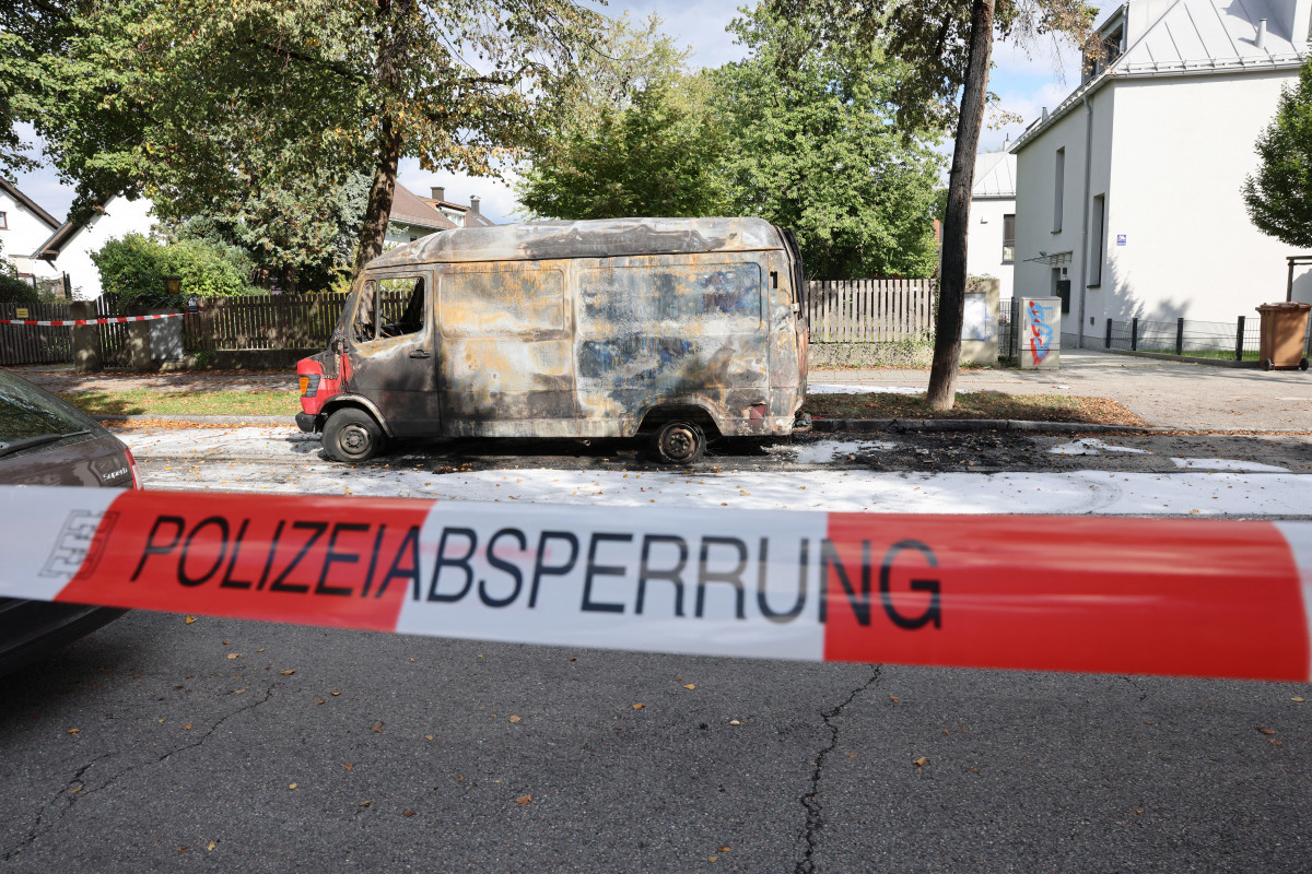 Policiais inspecionam uma van incendiada estacionada na rua perto do local onde explosões foram ouvidas /ALEXANDRA BEIER / AFP