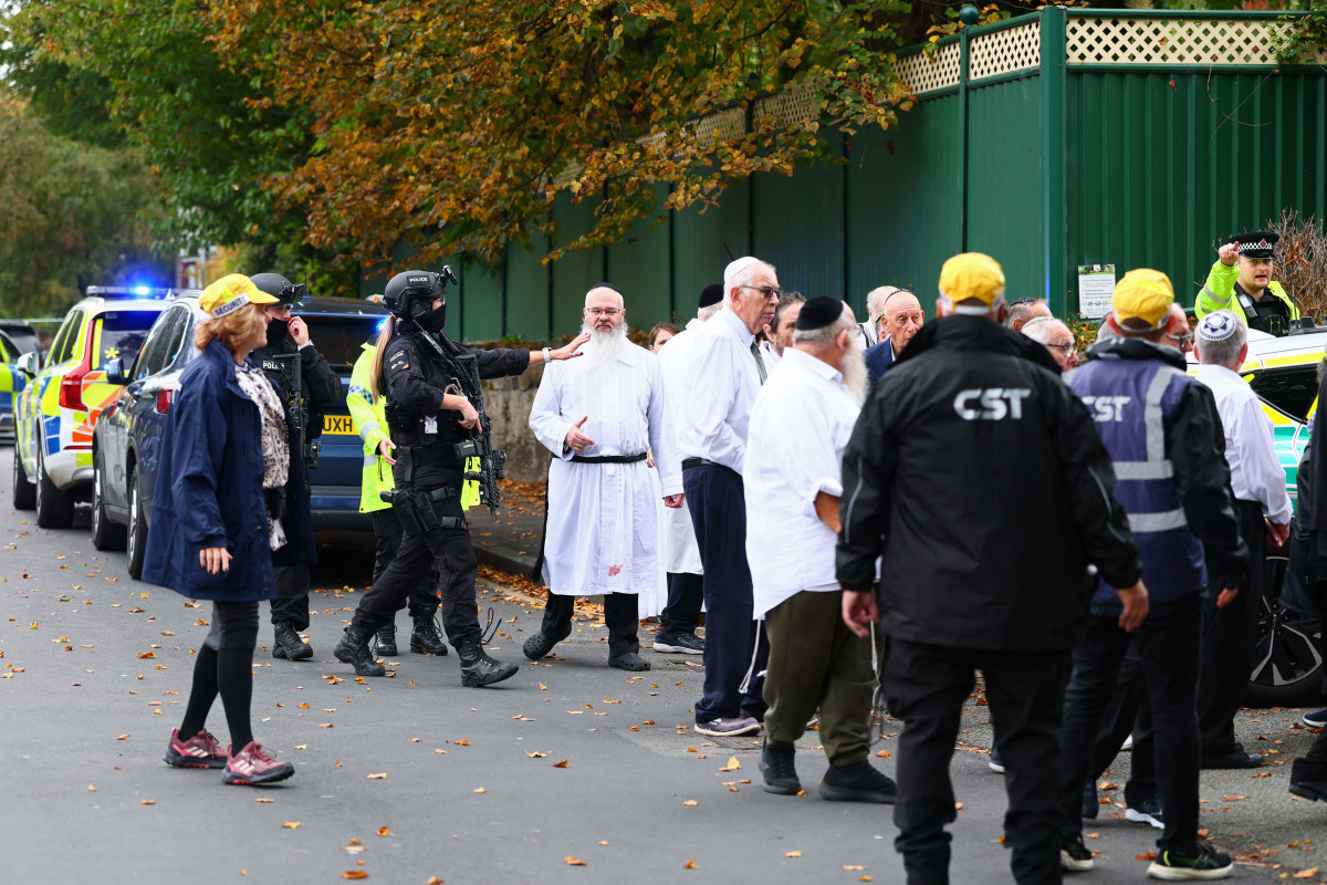 Policiais armados conversam com membros da comunidade perto da sinagoga da Congregação Hebraica de Heaton Park em Crumpsall, norte de Manchester/Paul Currie/AFP