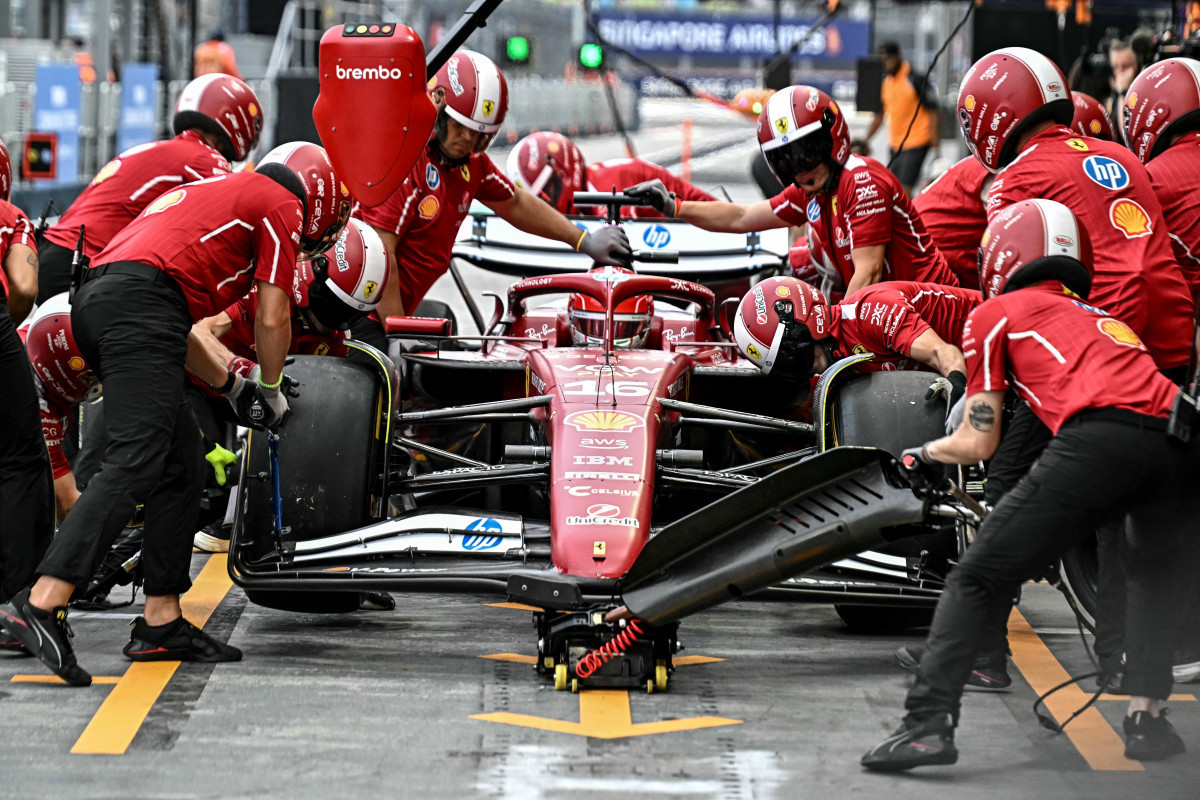 Mecânicos da Ferrari e o piloto Charles Leclerc/LILLIAN SUWANRUMPHA / AFP