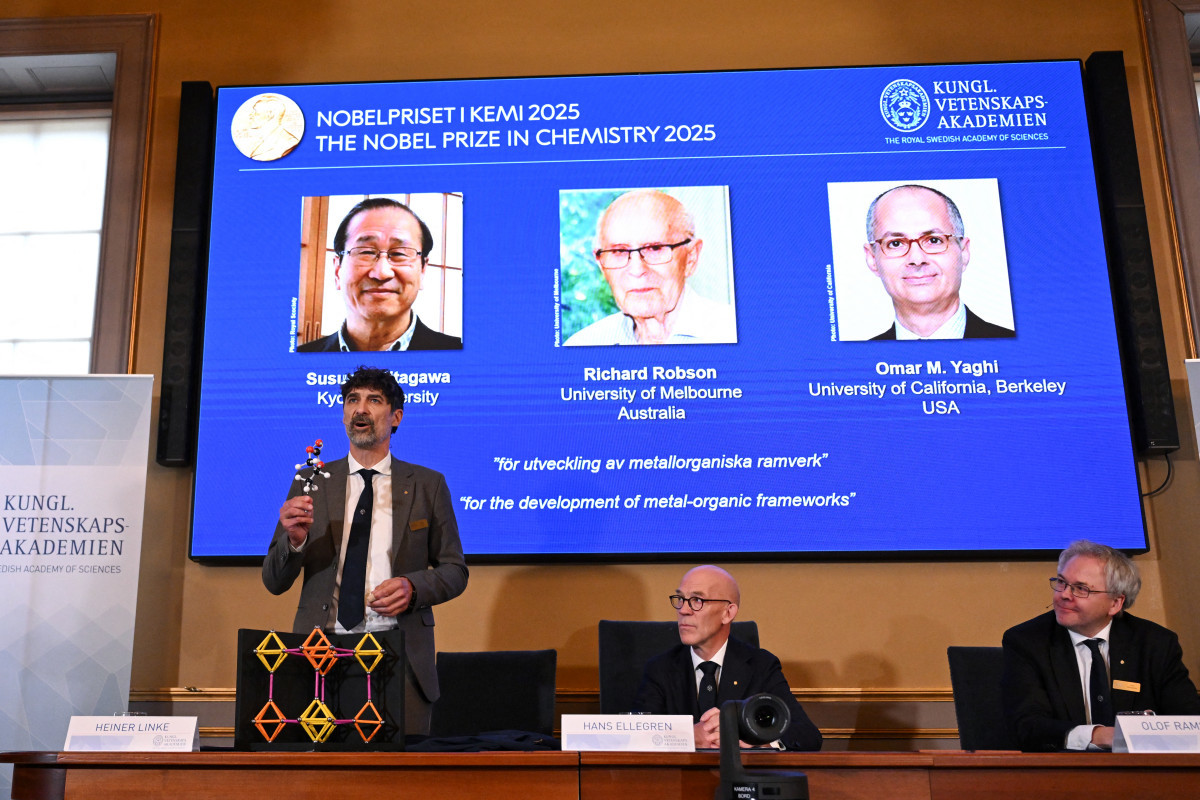 Heiner Linke (E), presidente do Comitê Nobel de Química, explica um modelo enquanto Hans Ellegren (C), secretário-geral da Real Academia Sueca de Ciências, e Olof Ramstroem, membro do Comitê Nobel de Química, ouvem durante uma coletiva de imprensa sobre o anúncio dos vencedores do Prêmio Nobel de Química de 2025 na Real Academia Sueca de Ciências em Estocolmo, Suécia/ AFP
