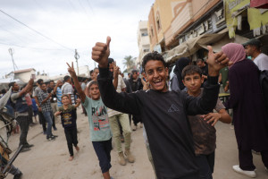Jovens palestinos comemoram perto do hospital Shuhada al-Aqsa, em Deir al-Balah, no centro da Faixa de Gaza
