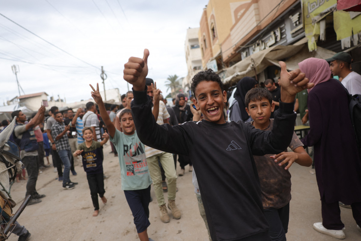 Jovens palestinos comemoram perto do hospital Shuhada al-Aqsa, em Deir al-Balah, no centro da Faixa de Gaza (AFP) Jovens palestinos comemoram perto do hospital Shuhada al-Aqsa, em Deir al-Balah, no centro da Faixa de Gaza/AFP