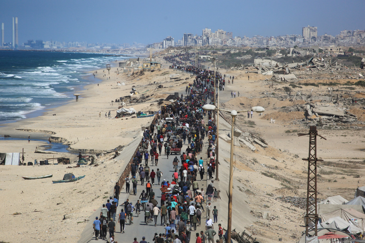 Palestinos seguem pela estrada Al-Rashid em direção à Cidade de Gaza, partindo de Nuseirat, no centro da Faixa de Gaza, em 10 de outubro de 2025. As forças israelenses declararam um cessar-fogo e se retiraram de algumas posições em Gaza no dia 10, enquanto milhares de palestinos deslocados começaram a retornar para casa e as famílias dos reféns de 7 de outubro aguardavam notícias. O gabinete do primeiro-ministro de Israel afirmou que o governo 