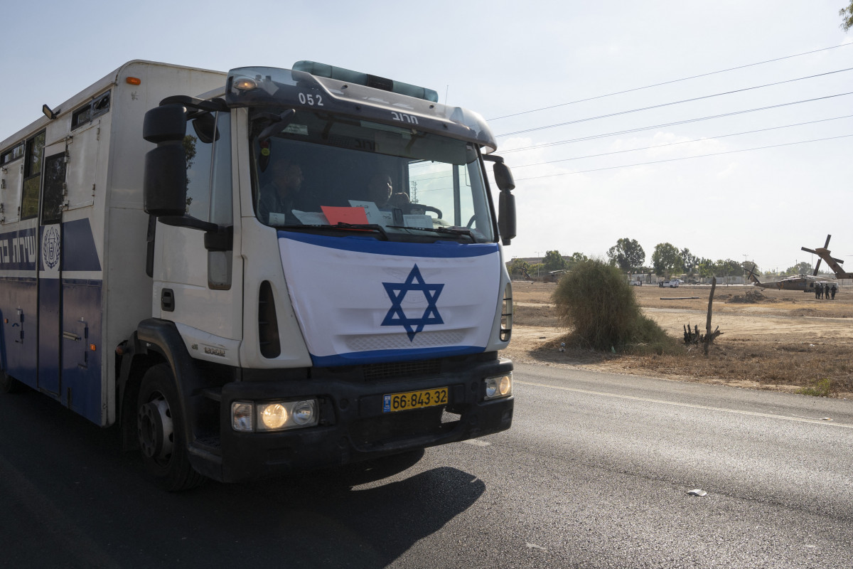 Um veículo prisional israelense, transportando prisioneiros palestinos libertados, passa perto da base militar de Reim, perto da fronteira com Gaza, no sul de Israel, em 13 de outubro de 2025. O grupo militante palestino deveria libertar todos os reféns israelenses sobreviventes em 13 de outubro em troca de prisioneiros palestinos mantidos por Israel, enquanto o presidente dos EUA, Donald Trump, se dirigia à região para uma cúpula de paz após declarar o fim da guerra. A visita relâmpago de Trump a Israel e ao Egito visa celebrar seu papel na mediação do cessar-fogo e do acordo de libertação de reféns da semana passada — mas ocorre em um momento delicado, enquanto Israel e o Hamas negociam o que vem a seguir. (Foto de Maya LEVIN / AFP) ( AFP)
