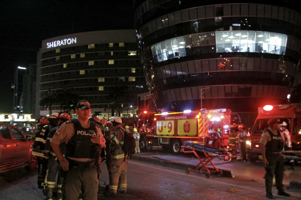 
Policiais e bombeiros são vistos no local onde um suposto carro-bomba explodiu em frente a um shopping center no norte de Guayaquil, Equador, em 14 de outubro de 2025. (Foto de Gerardo MENOSCAL / AFP) ( AFP)