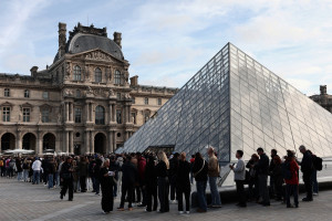 Visitantes fazem fila em frente à Pirâmide do Louvre, projetada pelo arquiteto sino-americano Ieoh Ming Pei, com o Museu do Louvre ao fundo, em Paris, em 22 de outubro de 2025. 