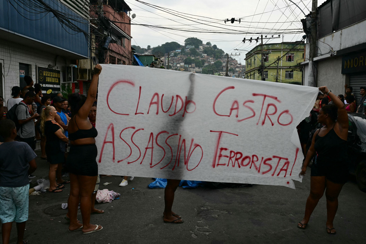 Moradores protestam enquanto colocam corpos em fila na Praça São Lucas, na favela Vila Cruzeiro, no complexo da Penha, no Rio de Janeiro ( Pablo PORCIUNCULA / AFP)