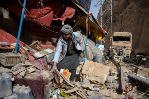 Um comerciante afegão procura por restos mortais em frente a uma loja danificada ao longo de uma rodovia após um terremoto em Tang-e Tashqurghan, no distrito de Khulm, província de Samangan, em 3 de novembro de 2025. Um forte terremoto matou pelo menos 20 pessoas no norte do Afeganistão, disseram as autoridades em 3 de novembro, apenas alguns meses depois de outro tremor mortal que deixou o país em choque. (Foto de Atif Aryan / AFP)
