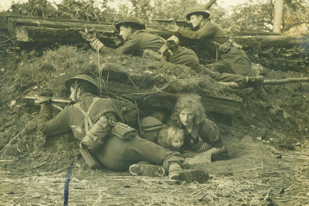  1944. Credito: Arquivo/DP. Segunda Guerra Mundial. Civis holandeses buscam abrigo sob uma trincheira onde soldados britanicos lutam em Boxtel./ Arquivo/DP. 