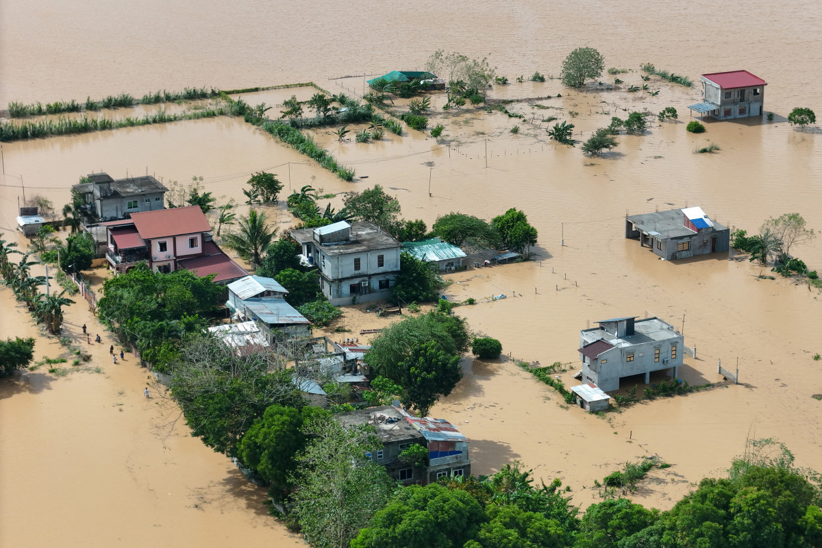 Esta foto mostra uma vista aérea de casas e terras agrícolas submersas pelas águas da enchente na cidade de Tuguegarao, província de Cagayan, ao norte de Manila, em 11 de novembro de 2025, enquanto as águas continuavam a inundar residências devido às fortes chuvas provocadas pelo supertufão Fung-wong. Vilarejos inteiros ficaram submersos e dezenas de cidades permaneceram sem energia elétrica em 10 de novembro, quando o tufão Fung-wong deixou as Filipinas após matar pelo menos cinco pessoas e desalojar mais de um milhão. (Foto de John Dimain / AFP)/ AFP