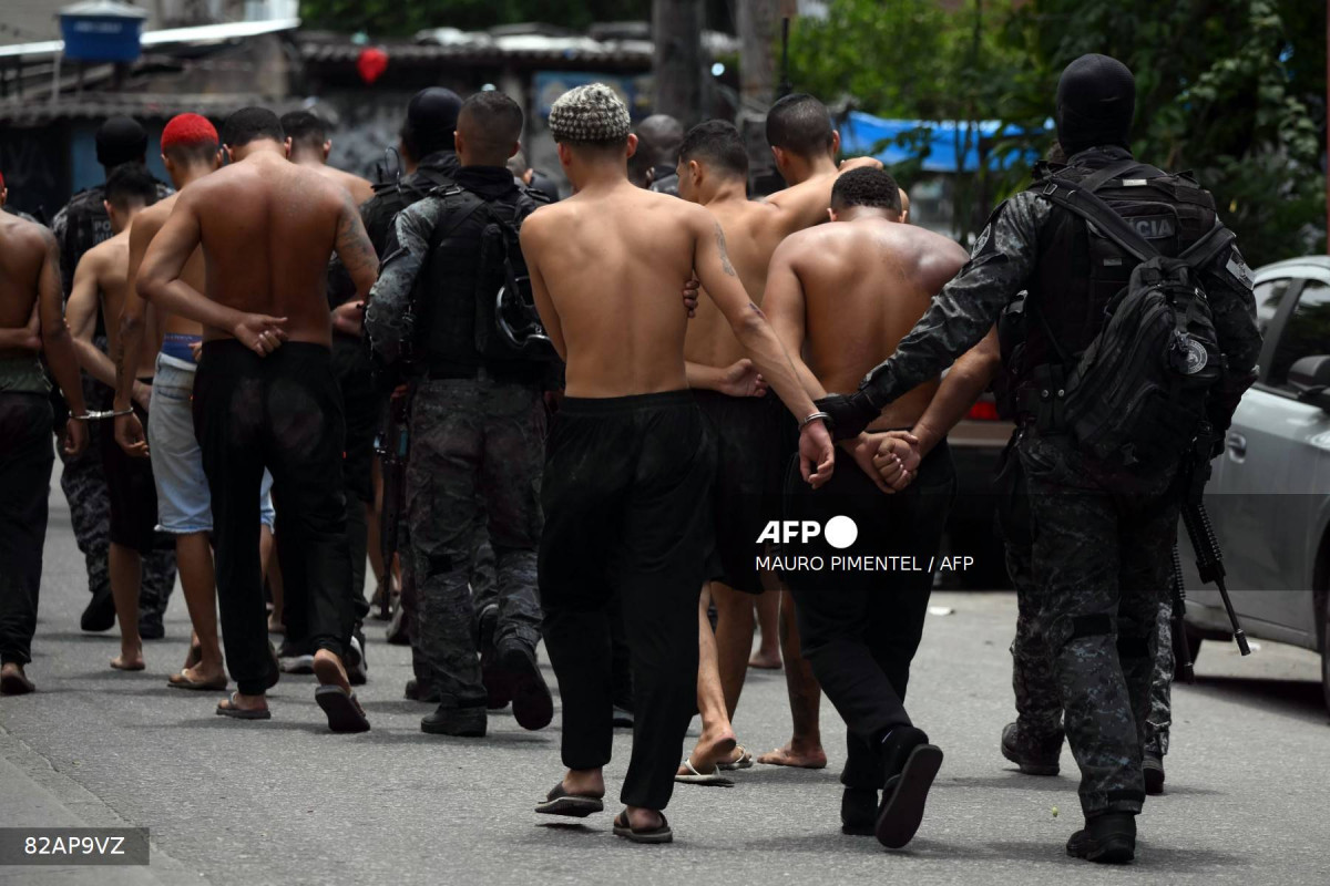 Polícia leva suspeitos detidos na Operação Contenção, no Rio de Janeiro, no dia 28 de outubro/Foto por MAURO PIMENTEL  AFP