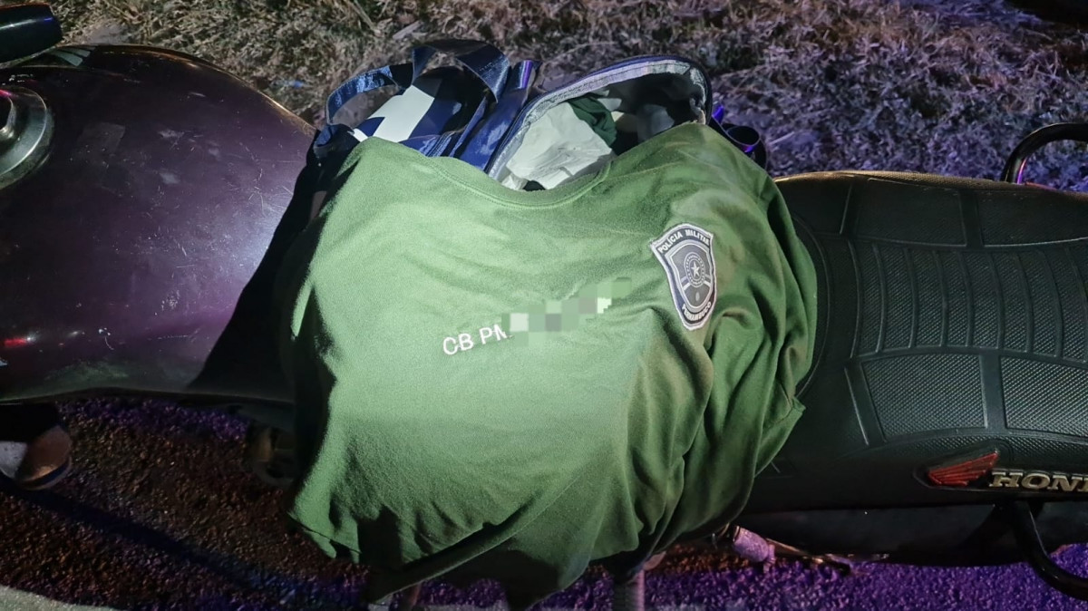 Duas camisas e uma carteira funcional da Polícia Militar com sinais de falsificação em nome do condutor foram encontradas em uma bolsa./Divulgação.