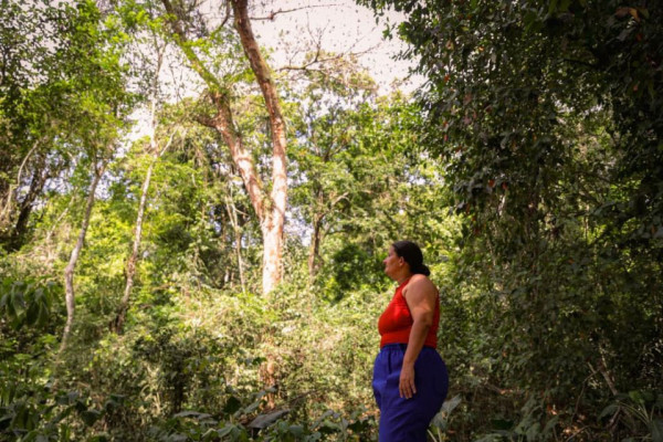 Fabiana contemplando quintal da casa da filha, que d&aacute; para uma floresta