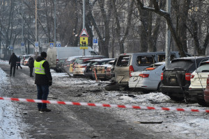 Carros danificados no local onde destro&ccedil;os de drones russos ca&iacute;ram durante um ataque a&eacute;reo em grande escala em Kiev