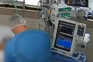 Técnico de enfermagem em leito onde morreu uma das vítimas/Reprodução