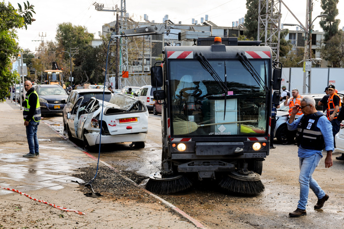 Forças de segurança israelenses e equipes de primeiros socorros inspecionam os danos no local de um ataque iraniano que atingiu um bairro residencial em Bat Yam, ao sul de Tel Aviv, em 9 de março/JACK GUEZ/AFP