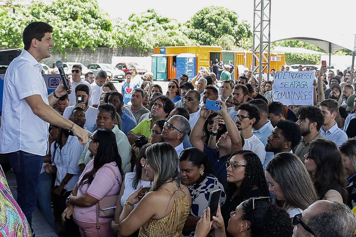 Moradores levaram cartaz para protestar contra desapropiração de casas para obra de ponte, em cerimônia com o prefeito João Campos (PSB) /Rafael Vieira/DP