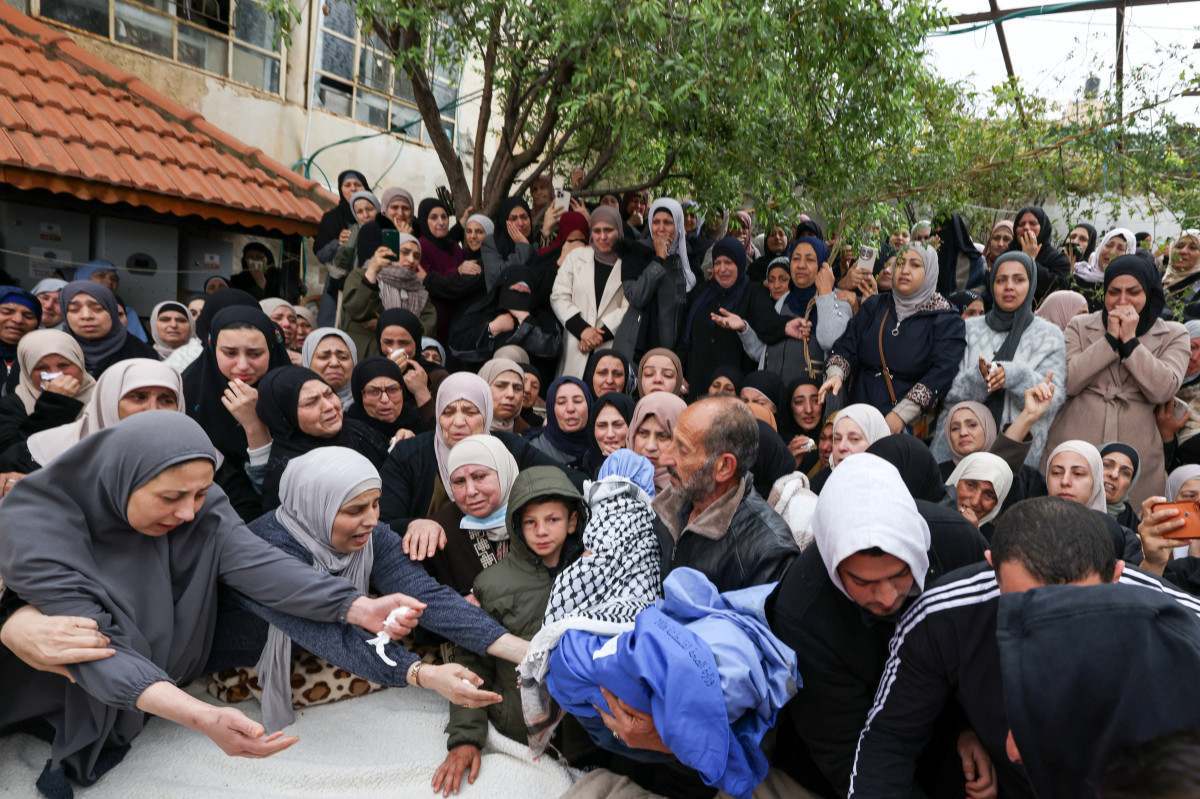 Um familiar carrega o corpo de Mohammed Bani Odeh, um dos dois meninos mortos junto com os pais por soldados israelenses enquanto estavam em um carro, durante o funeral na cidade de Tammun, na Cisjordânia/ JAAFAR ASHTIYEH / AFP