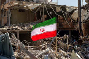 Bandeira iraniana em meio aos escombros de pr&eacute;dio residencial destru&iacute;do em Teer&atilde;