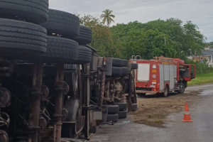 Carreta carregada de  min&eacute;rio tomba em curva de ala da BR-101 em Paulista e motorista fica ferido 