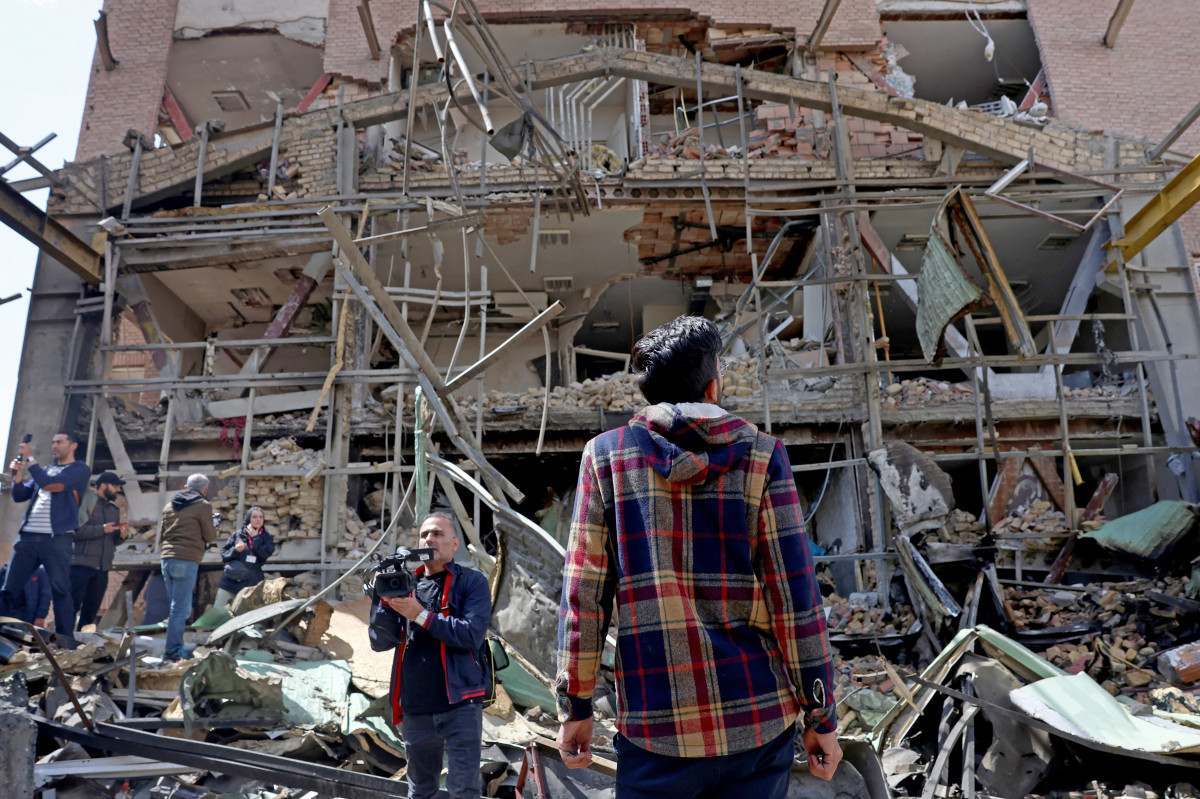 Representantes da mídia se reúnem em torno do prédio danificado da Universidade Shahid Beheshti após uma greve, em Teerã, em 4 de abril de 2026/AFP