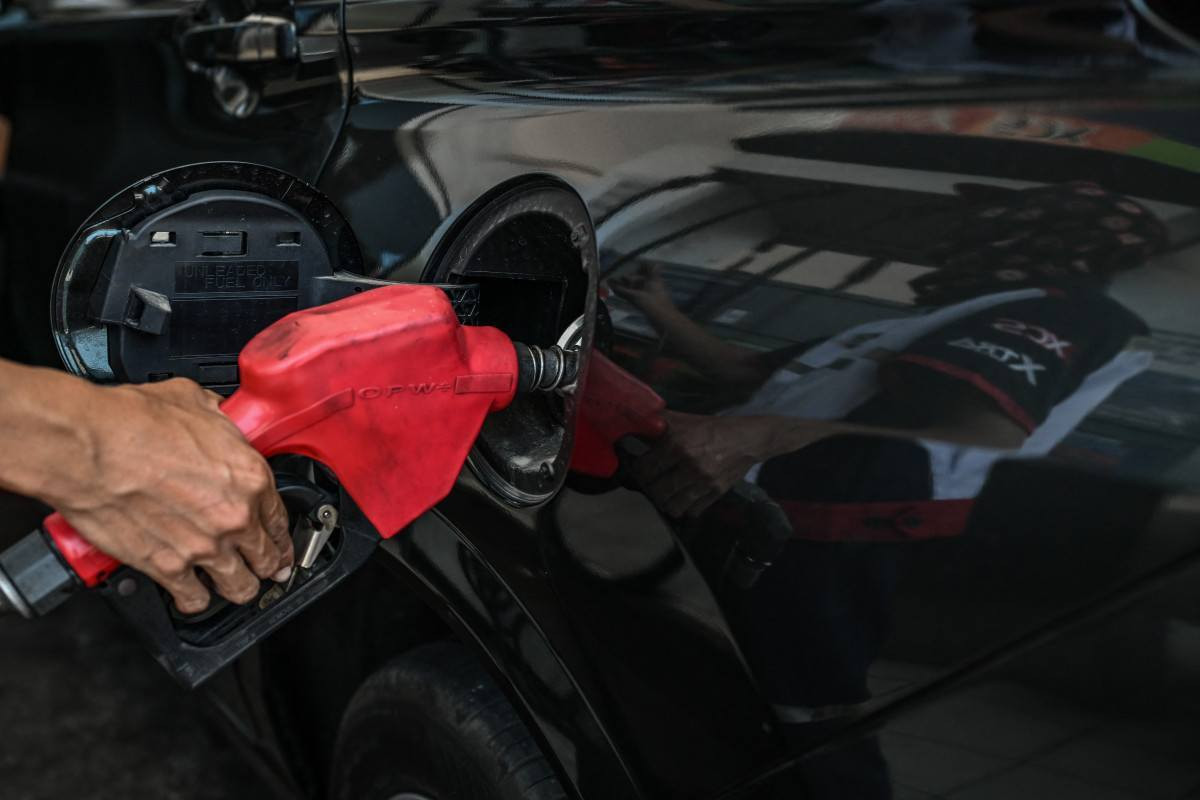 Um homem abastece o tanque de um carro em um posto de gasolina/JAM STA ROSA/AFP