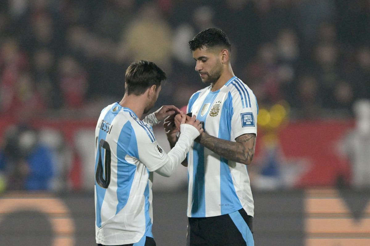 Lionel Messi e Cristian Romero em partida da seleção argentina/RODRIGO ARANGUA / AFP