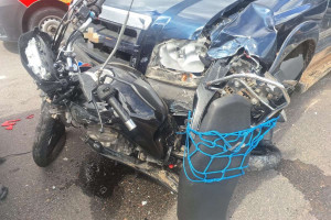 A moto ficou imprensada entre uma caminhonete e um carro