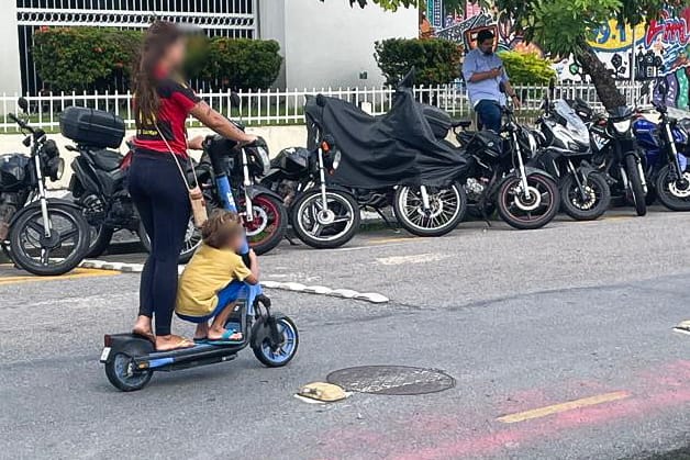 Mulher usa patinete com criança /DP