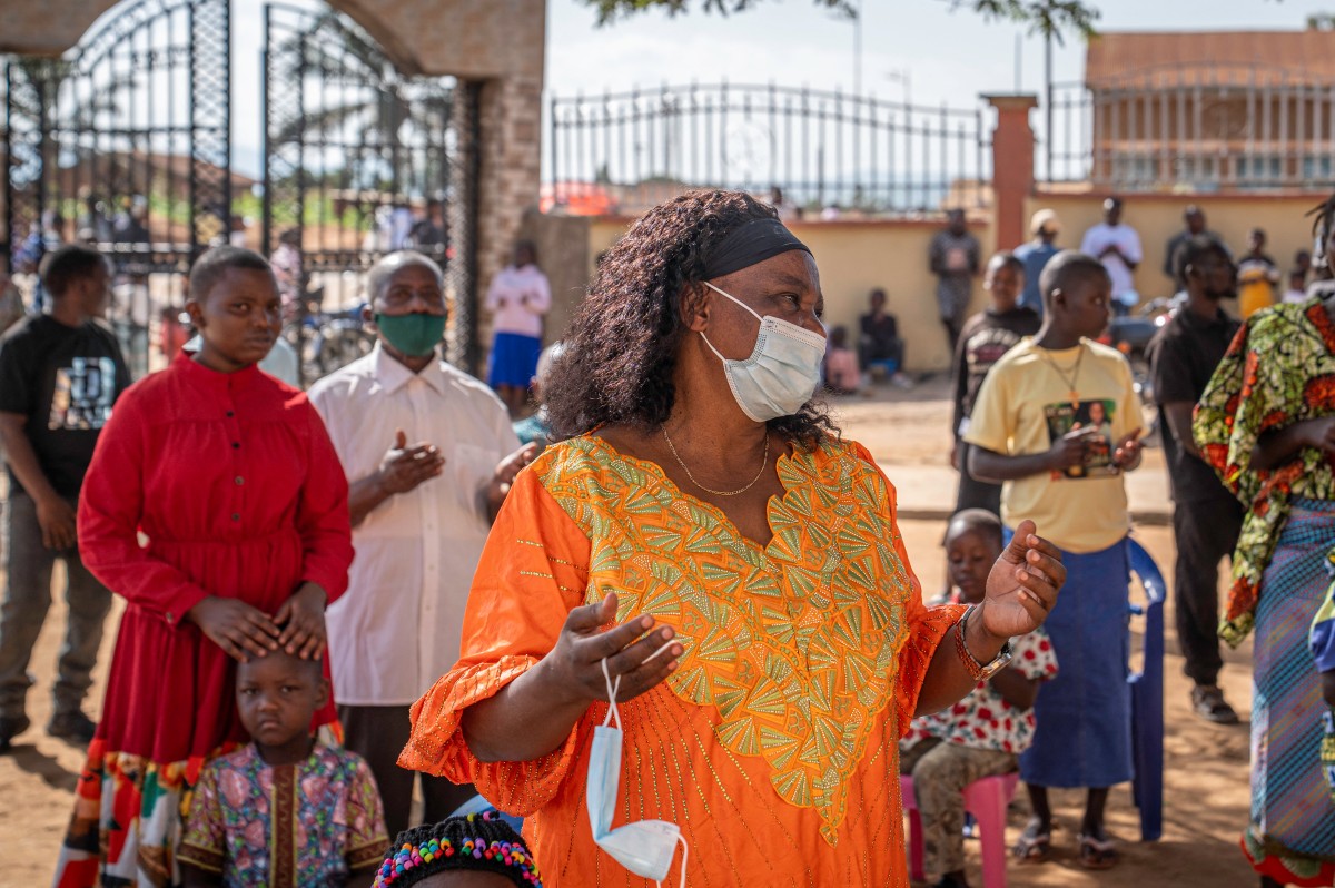 Um católico reza usando máscara, seguindo as instruções das autoridades locais para limitar a propagação do surto de Ebola no leste da República Democrática do Congo, durante uma missa na Catedral de Bunia, em Bunia, em 24 de maio de 2026. / AFP