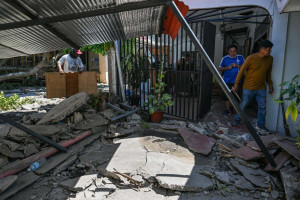 Moradores limpam suas casas danificadas ap&oacute;s um terremoto de magnitude 7,8 em General Santos City, em 9 de junho de 2026