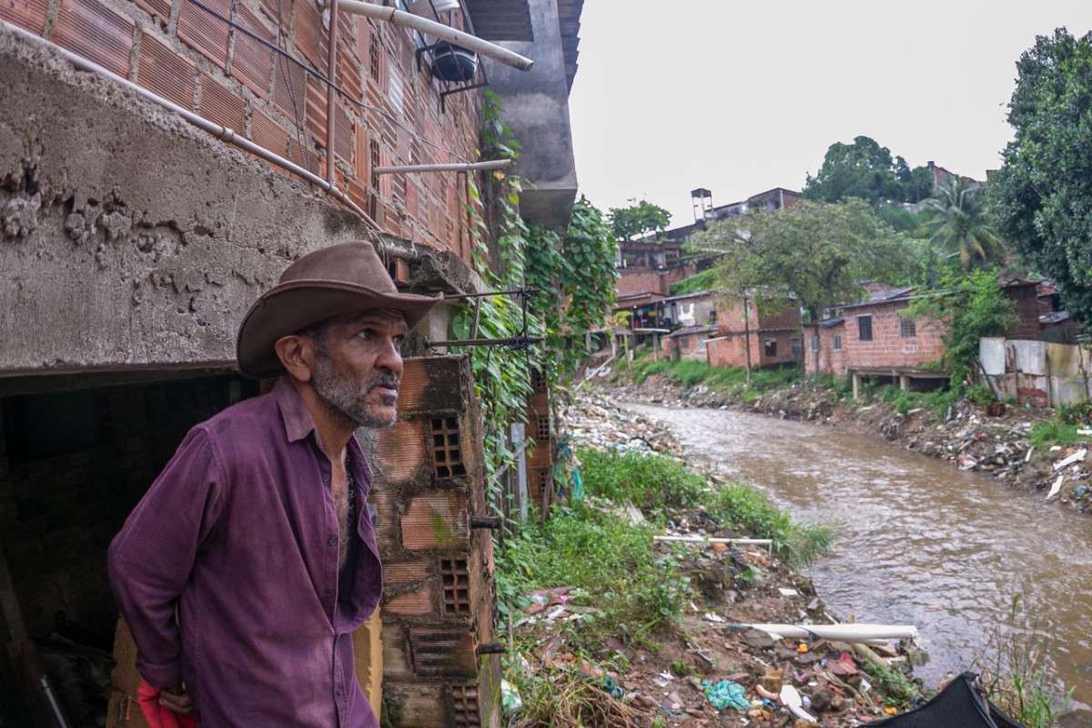 Manoel despeja os esgotos de casa no Rio Japão, afluente do Capibaribe (Rafael Vieira/DP Foto)