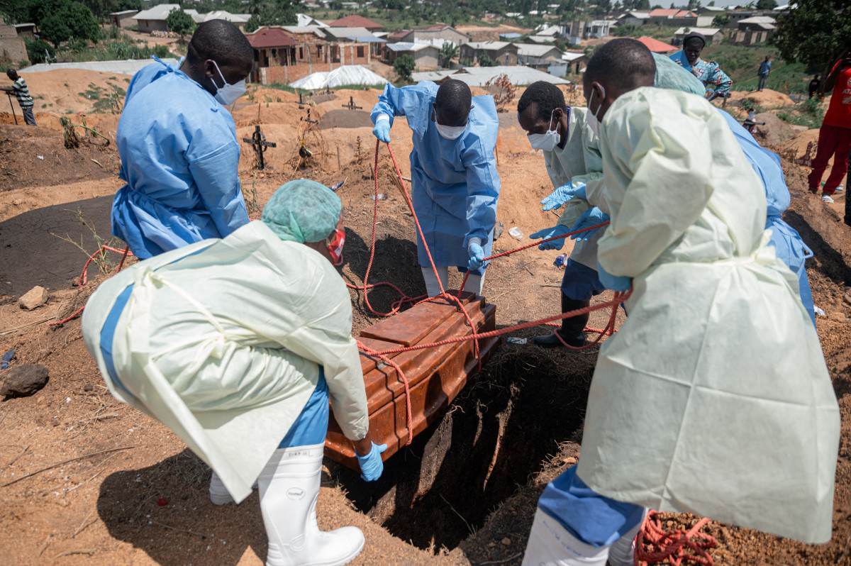 Equipes da Cruz Vermelha e do Crescente Vermelho transportam o corpo de um quarto &oacute;rf&atilde;o que morreu de doen&ccedil;a pelo v&iacute;rus/Jospin Mwisha/AFP