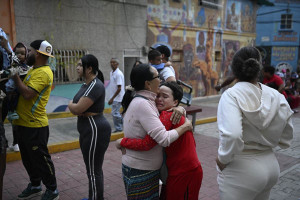 Mulher consola uma crian&ccedil;a na rua ap&oacute;s um terremoto em Caracas