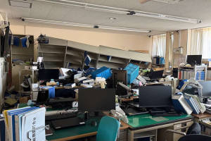 Material de escrit&oacute;rio e m&oacute;veis espalhados por uma sala no pr&eacute;dio da Prefeitura de Hashikami ap&oacute;s um terremoto