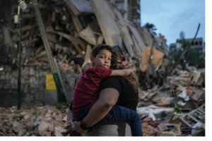 Pessoas passam por um pr&eacute;dio que desabou ap&oacute;s um terremoto em Caracas, em 25 de junho de 2026