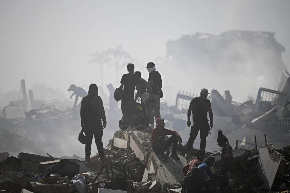 Voluntários buscam possíveis vítimas em um prédio que desabou após dois terremotos em Caraballeda, no estado de La Guaira, a cerca de 40 km a nordeste de Caracas/FEDERICO PARRA/AFP